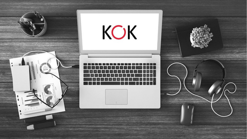 Laptop auf dem Schreibtisch mit KOK-Logo auf dem Bildschirm